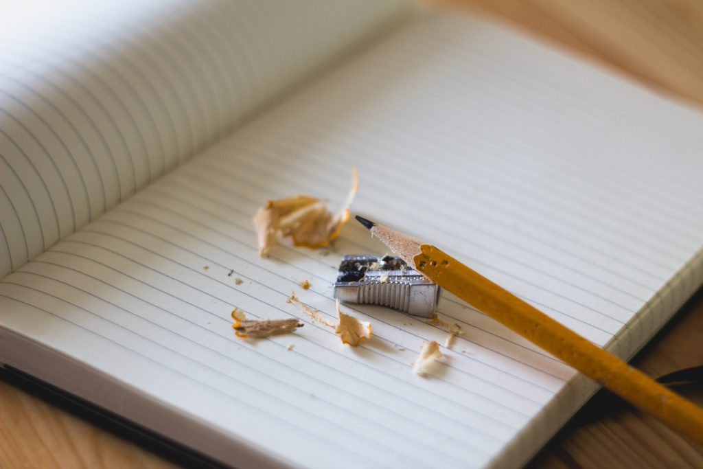 photo of sharpened pencil and notebook