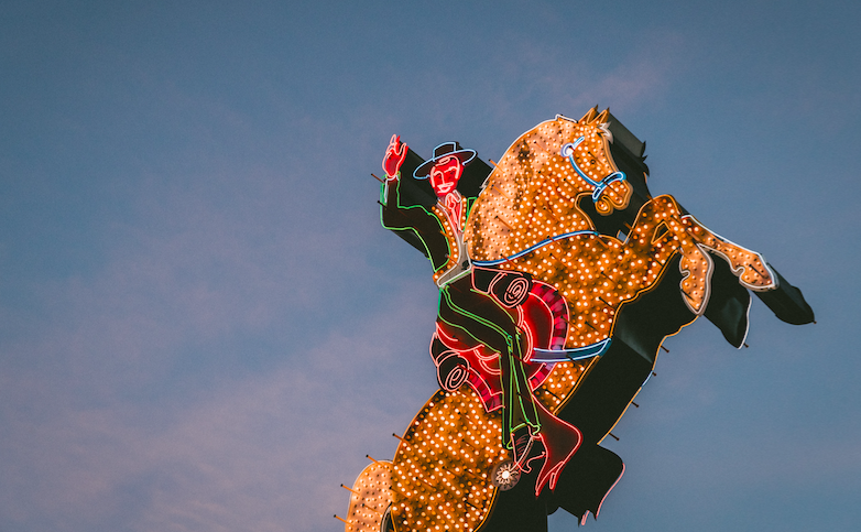 Neon-lit sculpture of cowboy on rearing horse