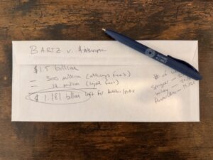 a photo of an envelope with math scribblings on the back, trying to determine the payout amounts for the settlement