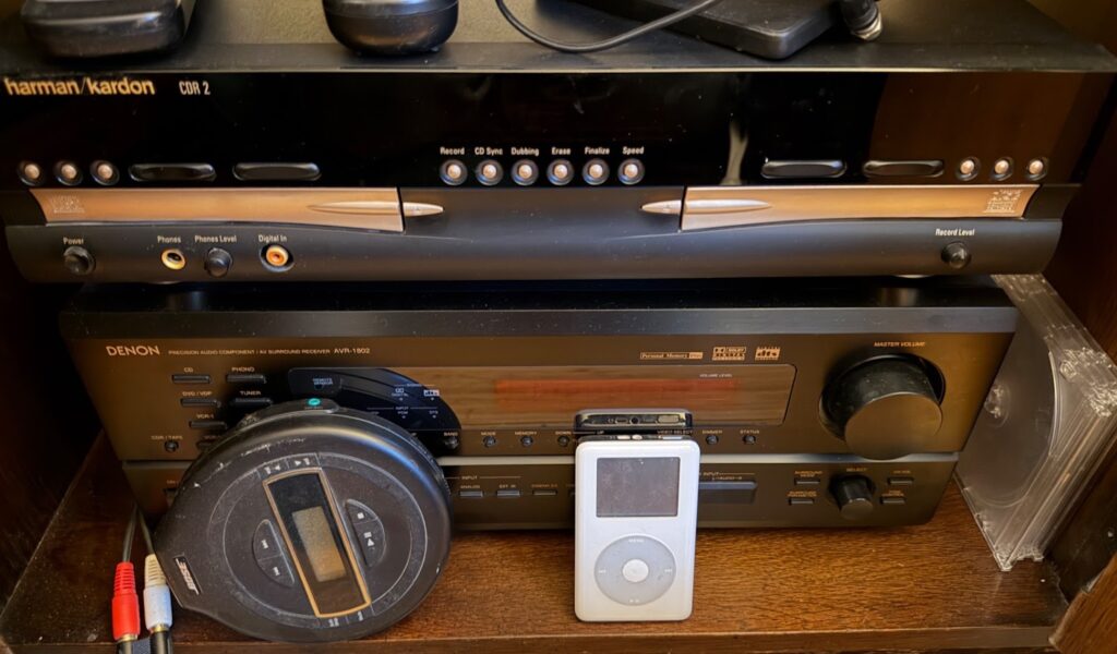 Photograph of components in a stand-alone audio system, including a dual CD player/recorder, a portable CD player, and a Clickwheel iPod.